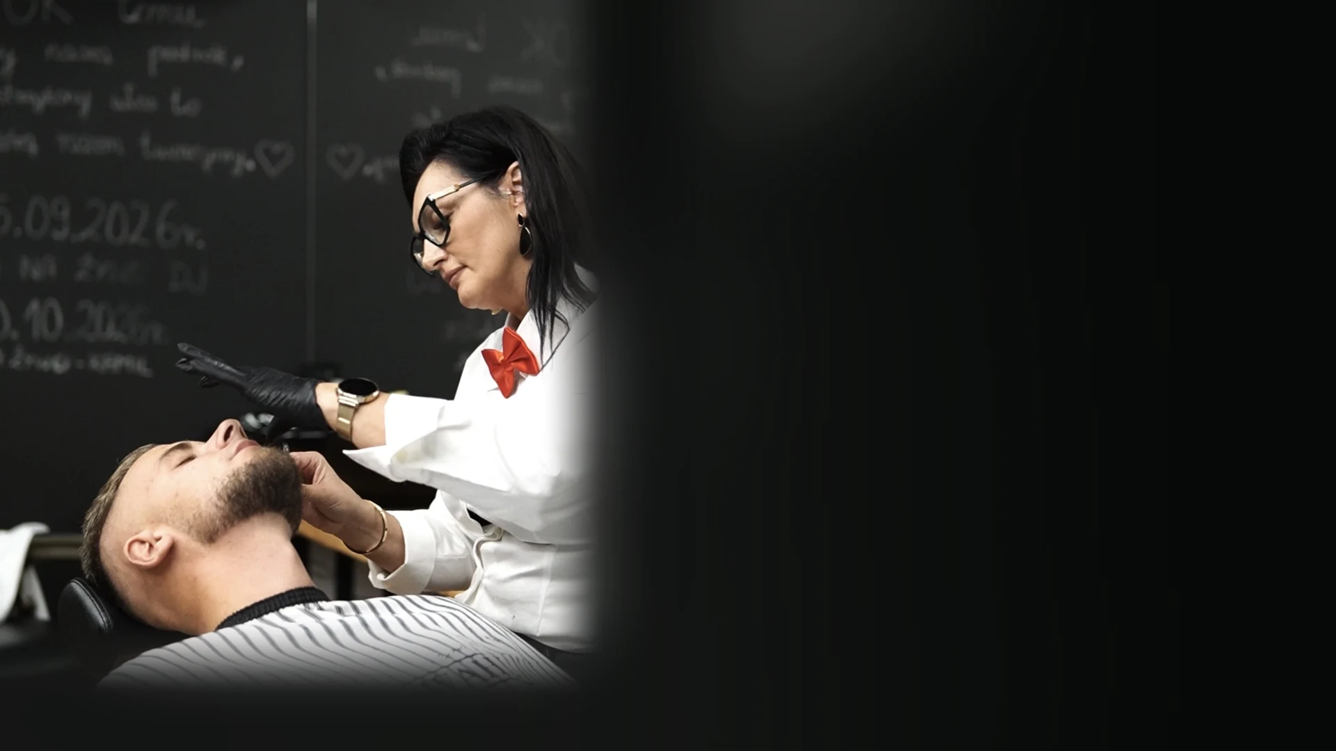 Grażyna Schwann pracuje brzytwą przy kliencie w salonie.